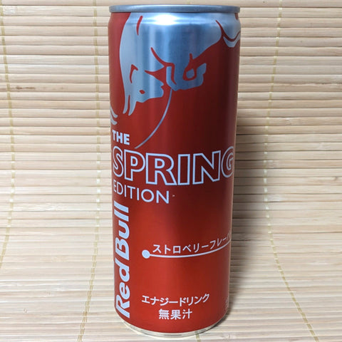 A can of Red Bull Energy Soda with Strawberry flavor, Spring Edition, on a bamboo mat background.
