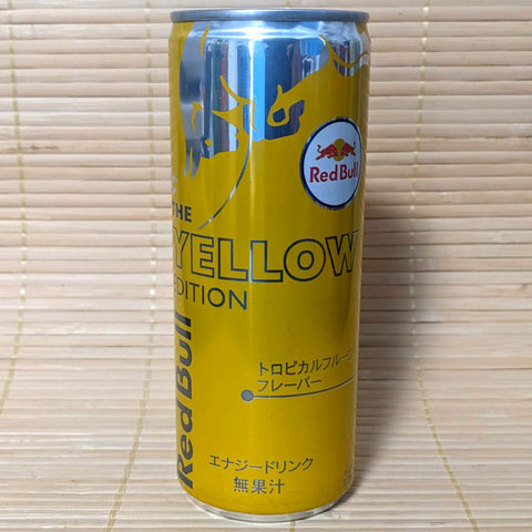 A can of Red Bull Energy YELLOW Soda with a tropical fruit flavor. The can is yellow with red and white branding and text.