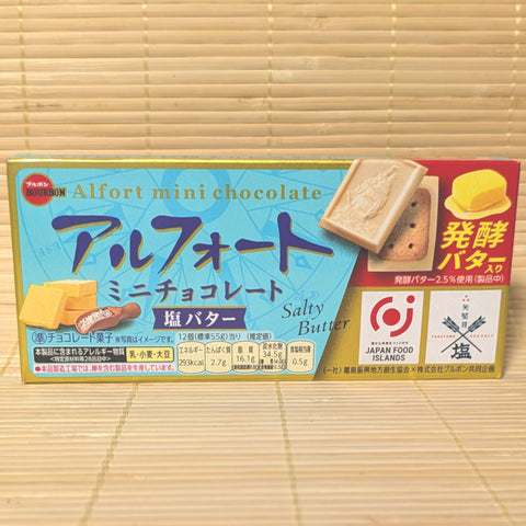 A light blue and gold box of Bourbon Alfort Mini Chocolate Salty Butter showing a chocolate sailboat biscuit, butter, and a sea salt logo on a tatami background.