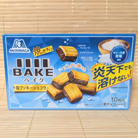 A bright blue box of Morinaga BAKE Salty Chocolate Cookie showing a small wooden bowl of white rock salt and cross sections of baked chocolate biscuits on a tatami background.