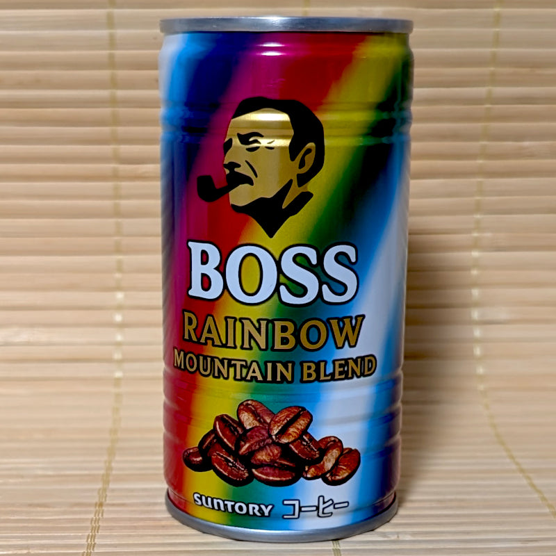A colorful rainbow-striped can of Suntory BOSS Rainbow Mountain Blend coffee with the iconic pipe-smoking logo, on a Japanese tatami background.