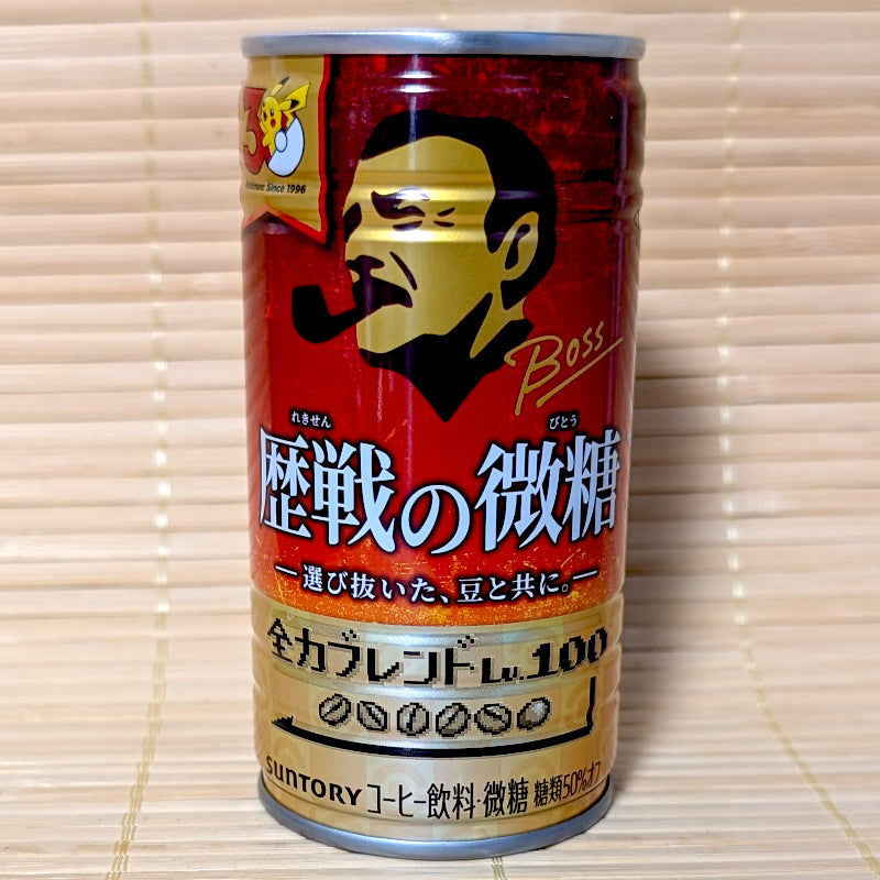 A metallic red 185g can of Suntory BOSS Rekisen no Bitou Low Sugar Coffee featuring the Pokémon 30th Anniversary logo on a bamboo mat.