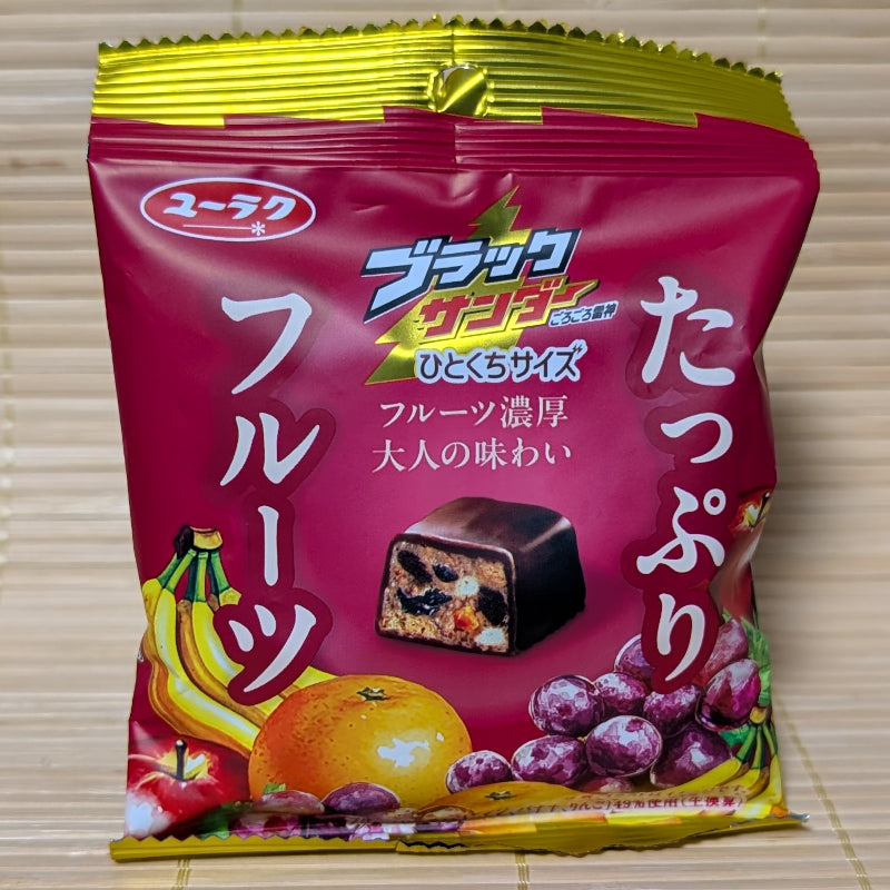 A pack of Black Thunder Fruit Mix chocolate displayed on a tatami background.