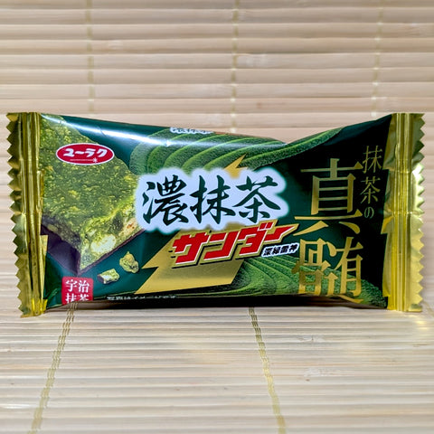 A green and gold wrapper of Black Thunder Rich Matcha chocolate showing a cross-section of the matcha layer and chocolate cookie core.