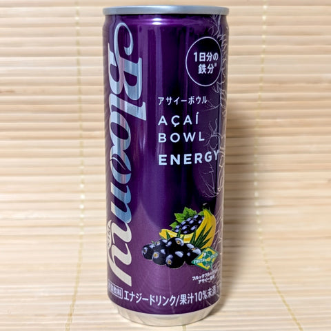 A sleek, deep purple 250ml can of Bloomy Acai Bowl Energy drink with botanical illustrations of acai berries and banana, on a traditional Japanese tatami background.