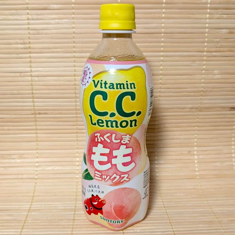 A 500ml bottle of Suntory C.C. Lemon Peach Mix with yellow and pink branding featuring a large peach. Displayed on a tatami surface.