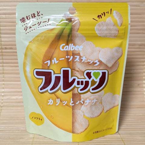 A Calbee freeze dried banana cracker chips in a heart shape. The package is displayed on a tatami surface