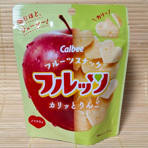 Calbee Apple Chips in heart shapes in a colorful foil package on a wooden background.