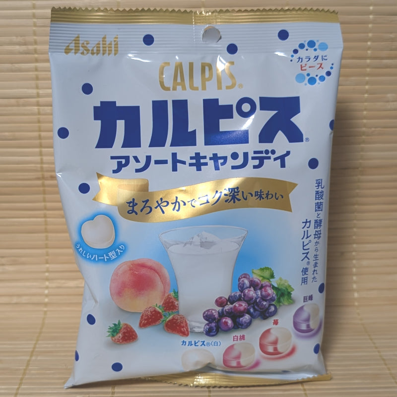 A white and blue bag of Asahi Calpis Assortment candy with images of strawberries, peaches, grapes, and heart-shaped candies.