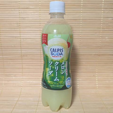A plastic PET bottle of CALPIS SODA - Melon Cream Soda with a green tinted liquid inside. The label has branding and flavor information in Japanese and English.
