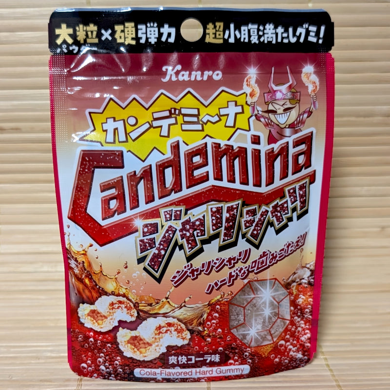 A Kanro Candemina Jari Shari Cola Flavored Hard Gummy package on a wooden surface