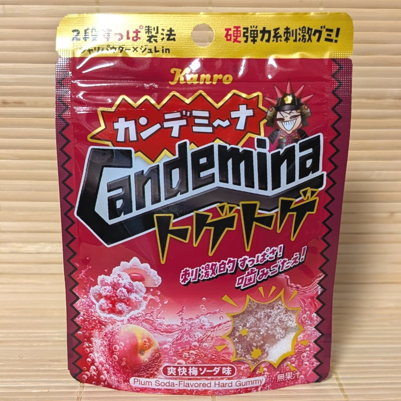 A jagged-edged red pouch of Kanro Candemina Toge-Toge gummies on a tatami background, featuring a thorny gummy illustration and a plum soda splash.