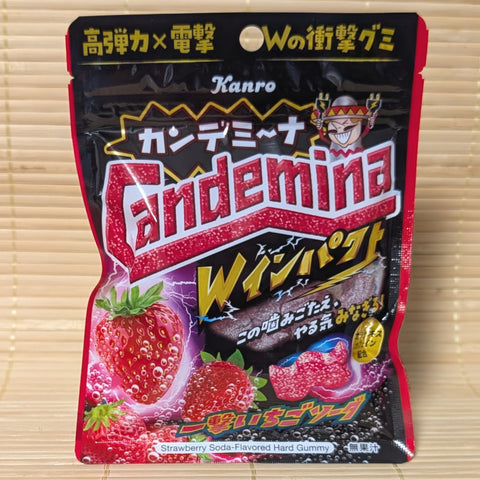 A pack of Candemia strawberry soda-flavored Double Impact hard gummy candies. Displayed on a wooden surface