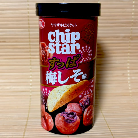 A slender red and pink Chip Star tube featuring illustrations of green shiso leaves and pink plum blossoms. Displayed on a tatami background.