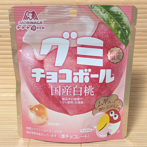 Pink package of Morinaga chocolate ball gummies with Japanese text and a cartoon character displayed on a wooden surface