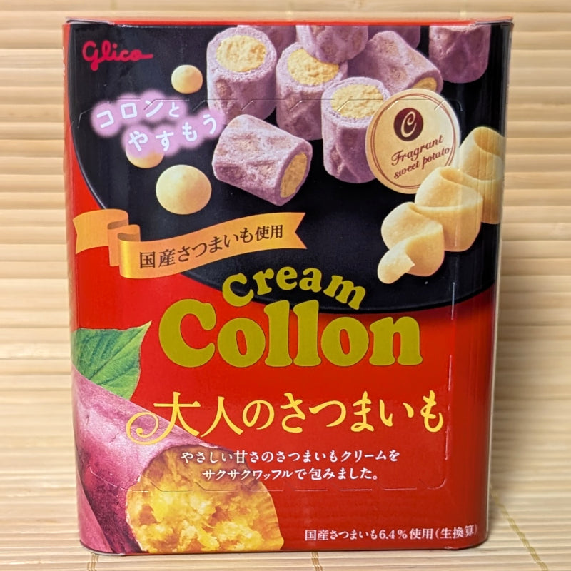 A red and black 48g box of Glico Cream Collon Otona no Satsumaimo cookies showing roasted Japanese sweet potato graphics and purple mini waffle rolls on a bamboo mat background.
