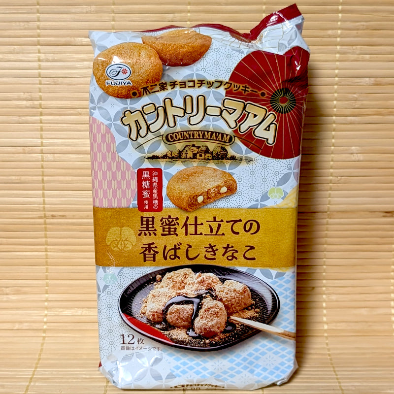 A white and red 12-pack bag of Fujiya Country Ma'am Kuromitsu Kinako soft cookies with mochi artwork on a bamboo mat background.
