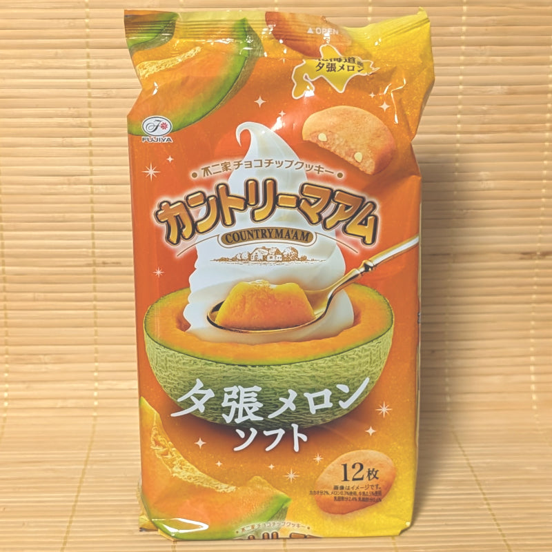A bright orange bag of limited edition Fujiya Country Ma'am Yubari Melon Soft Cream cookies featuring a melon filled with ice cream on a tatami background.