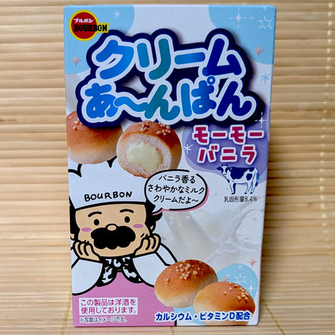 A light blue and pink box of Bourbon Cream Anpan vanilla cookies showing an anchor graphic, a cartoon chef, a spotted cow, and mini bread buns on a tatami background.