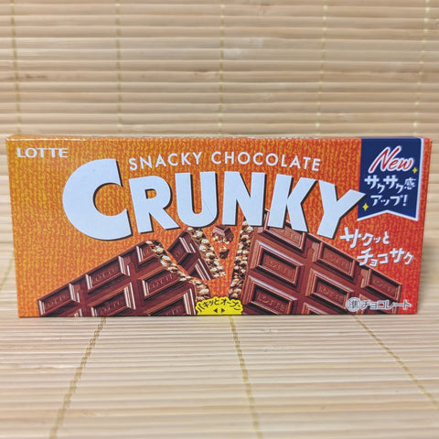 An orange and brown Lotte Crunky box on a tatami background showing a sectional chocolate bar and malt puff graphics.
