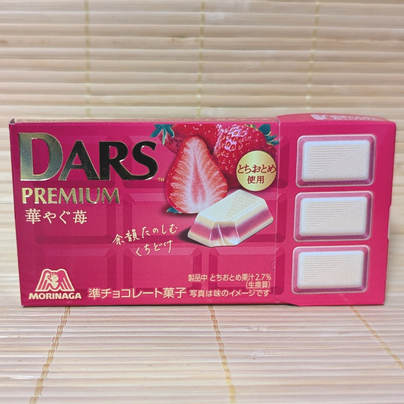 A magenta box of Morinaga DARS Premium Bright Strawberry chocolate showing 12 pieces and a cross-section of a fresh strawberry. Displayed on a tatami background.