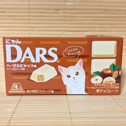 A box of Morinaga Cat DARS Hazelnut chocolate tablets displayed on a traditional tatami background.