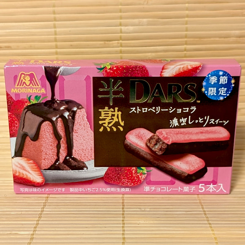 A pink 5-pack box of Morinaga Han-Juku DARS Strawberry Chocolat Sticks showing two-tone chocolate bars on a bamboo background.   