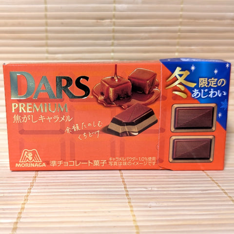 A box of Burnt Caramel DARS Premium chocolate displayed on a wooden surface.