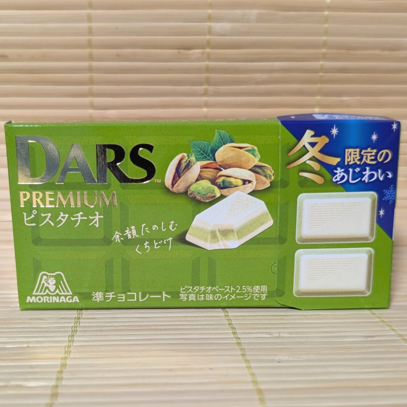 A box of DARS Premium Pistachio chocolate on a wooden surface background.