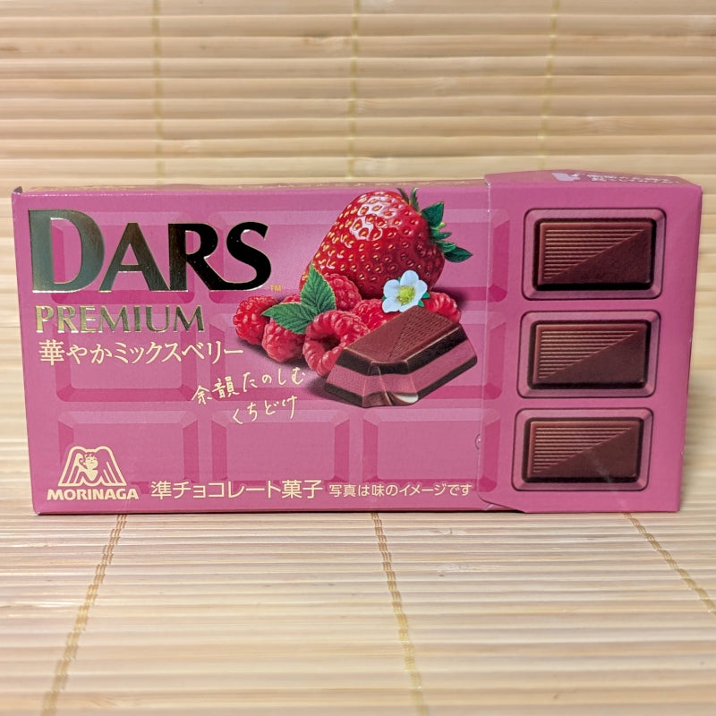 Pink DARS Premium chocolate box with strawberries and raspberries on a wooden surface