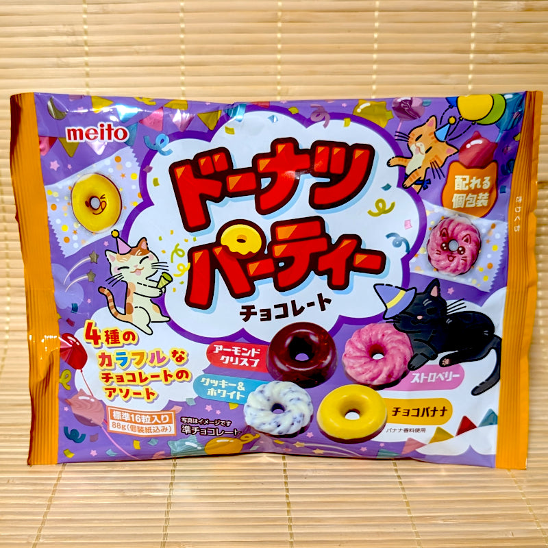 An 88g bag of Meito Donuts Party Chocolates displaying mini donut-shaped chocolates and cute cat illustrations on a bamboo mat.