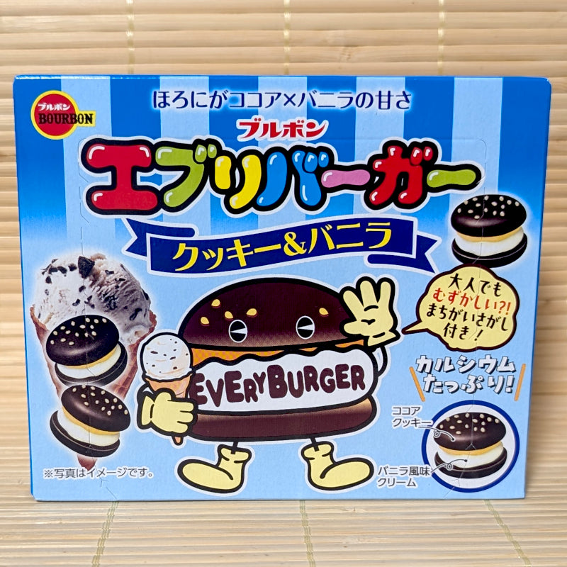 A blue striped 61g box of Bourbon Every Burger Cookies & Vanilla showing a hamburger cartoon character holding a cone against a textured tatami background.