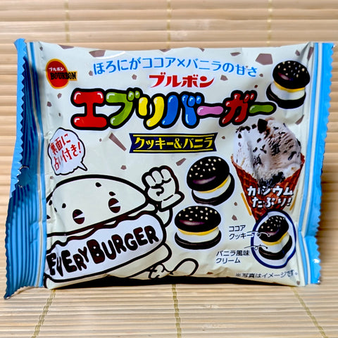 A white and blue 42g foil pouch of Bourbon Every Burger Cookies and Vanilla showing a burger mascot, mini cocoa cookie hamburgers, and an ice cream cone on a tatami background.