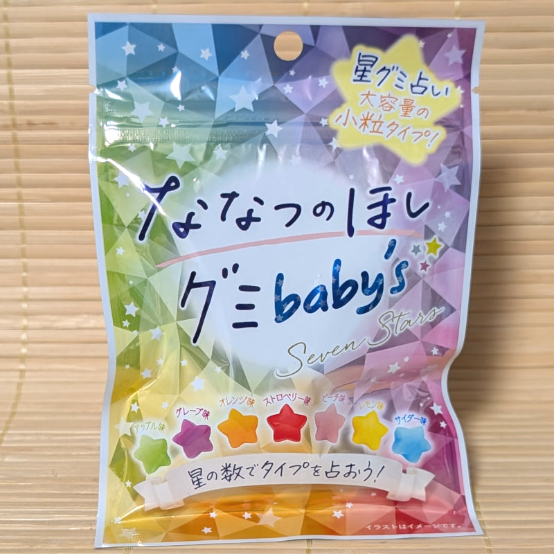 A pastel 54g pouch of Seven Star Gummy Baby's showing seven colored star gummies on a bamboo background.