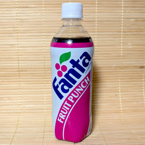 The reverse side of a 490ml PET bottle of Japanese Fanta Fruit Punch showing retro English font and deep magenta soda on a bamboo mat background.
