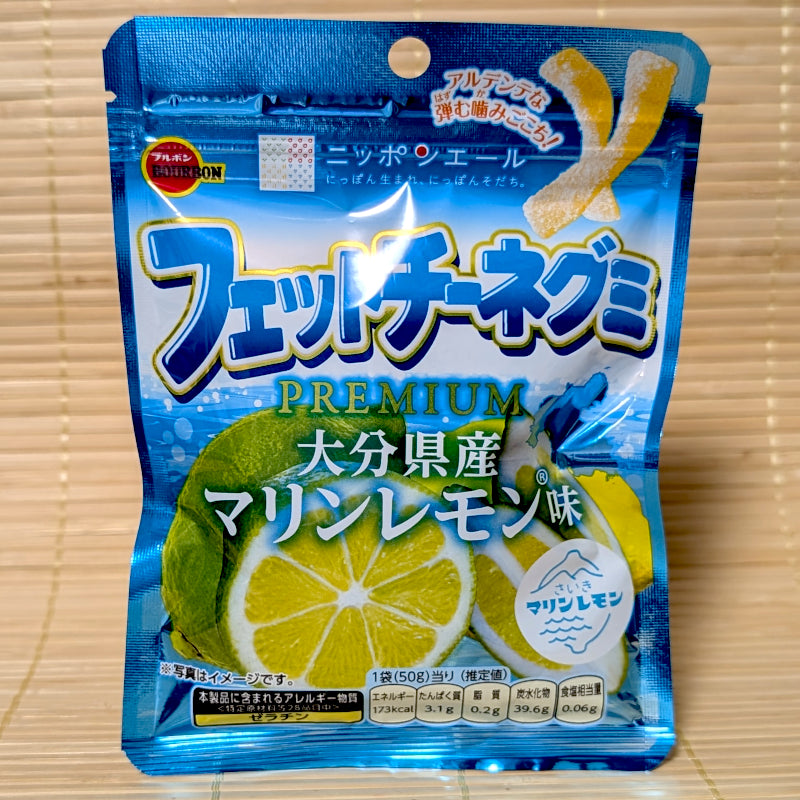 A metallic blue pouch of Bourbon Premium Fettuccine Marine Lemon gummies showing large sliced green citrus graphics on a tatami background.