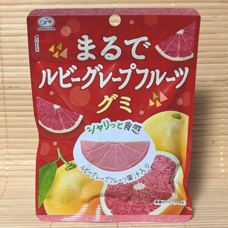 A bright red and yellow 44g pouch of Fujiya Marude Ruby Grapefruit gummies displaying fresh grapefruit graphics on a bamboo mat background.