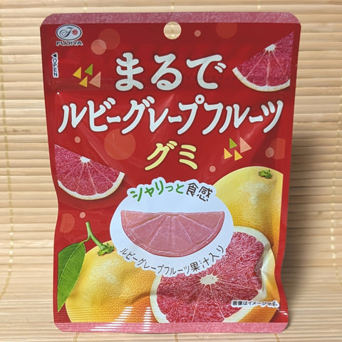 A bright red and yellow 44g pouch of Fujiya Marude Ruby Grapefruit gummies displaying fresh grapefruit graphics on a bamboo mat background.