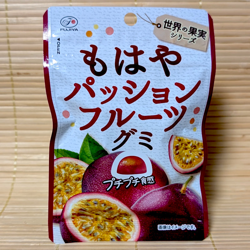 A bright blue and yellow beach themed pouch of Fujiya Mowaya Passion Fruit gummy candy showing a half-moon cut fruit graphic on a tatami background.
