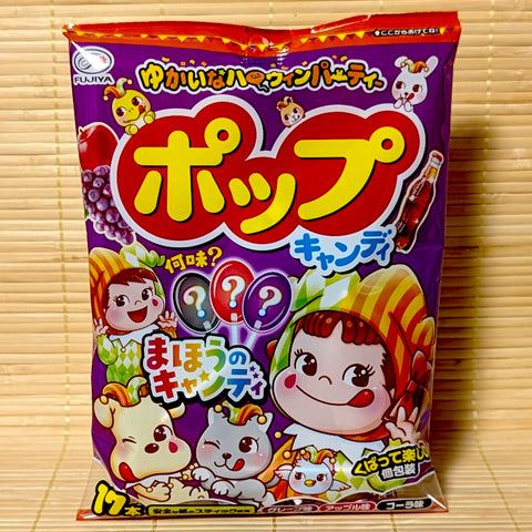 A purple Fujiya POP Candy Halloween bag showing Peko-chan in costume, mystery lollipops, and fruit illustrations on a bamboo background.
