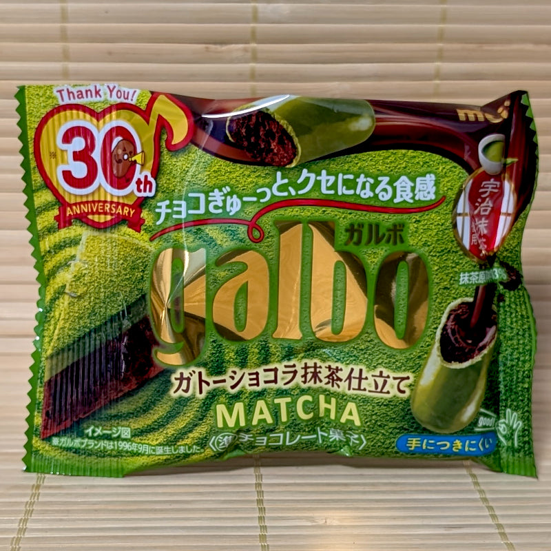 A green and gold 38g pouch of Meiji Galbo Matcha featuring a cross-section of the chocolate-infused biscuit and a 30th-anniversary logo.
