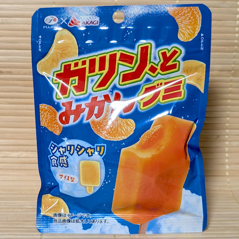 A blue resealable pouch of Fujiya Gatsun to Mikan gummies on a tatami background featuring a mikan ice bar and small ice bar shaped gummies.