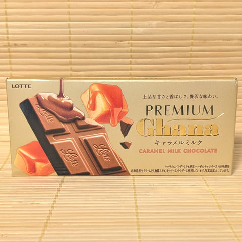 A Lotte Premium Ghana caramel milk chocolate bar displayed on a bamboo mat background