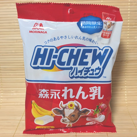 A white and red pouch of Morinaga Condensed Milk Hi-Chew showing fresh bananas, strawberries, and the iconic retro cow mascot on a tatami background.