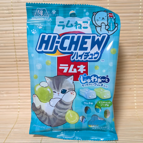 A light blue Mofusand kitten themed pouch of Hi-Chew Ramune and Muscat Soda displayed on a tatami background.