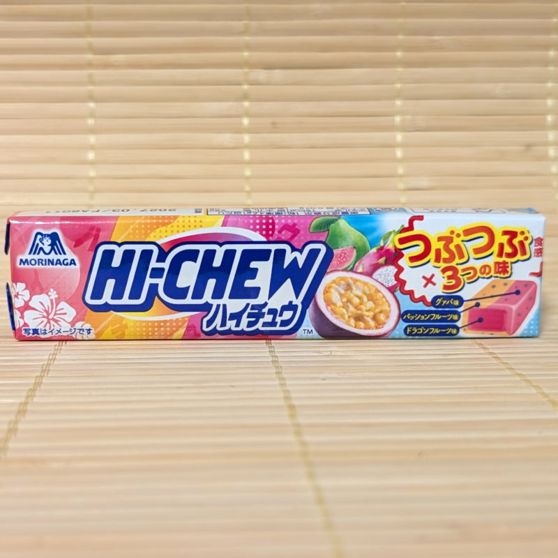 A vibrant pink and blue Hi-Chew pack showing guava, passion fruit, and dragon fruit graphics, photographed on a traditional Japanese tatami background.
