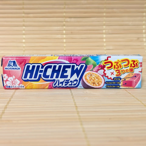 A vibrant pink and blue Hi-Chew pack showing guava, passion fruit, and dragon fruit graphics, photographed on a traditional Japanese tatami background.