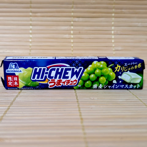A blue and green Hi-Chew Umai-Chew stick pack on a tatami background featuring Shine Muscat grapes and a diagram showing crunchy bits inside the chewy center.