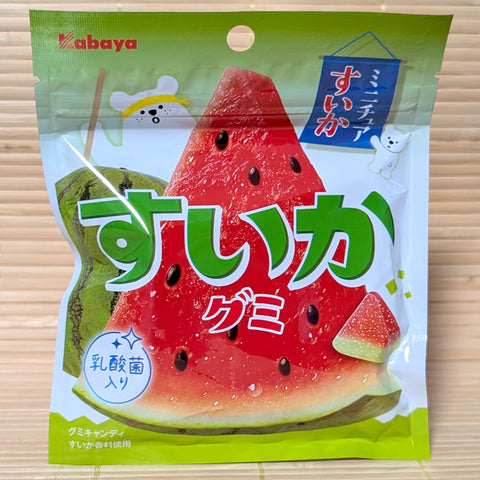 A green and white pouch of Kabaya Suika gummies featuring a large, vibrant slice of watermelon and a polar bear character. Displayed on a tatami background.