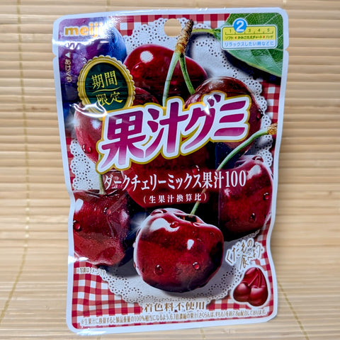 A white and red gingham checked pouch of Meiji Kaju Dark Cherry Mix gummies showing graphics of ripe dark cherries on a tatami background.